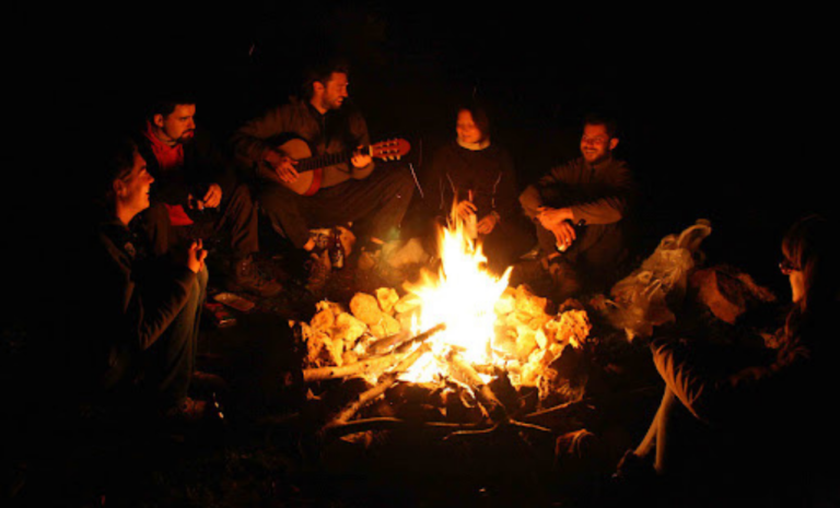 a group of people sitting around a fire Dandeli homestay